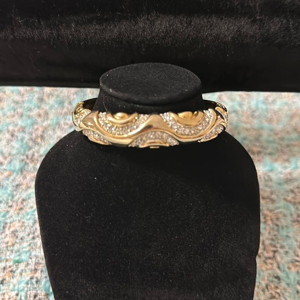 Gold tone jeweled wave detailed bangle bracelet